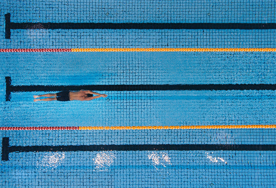 Individual swimming in an aesthetically arranged pool, symbolizing metric-based process mapping.