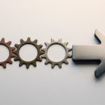 Gears aligned and merging into an arrow, symbolizing the process of Value Stream Transformation.